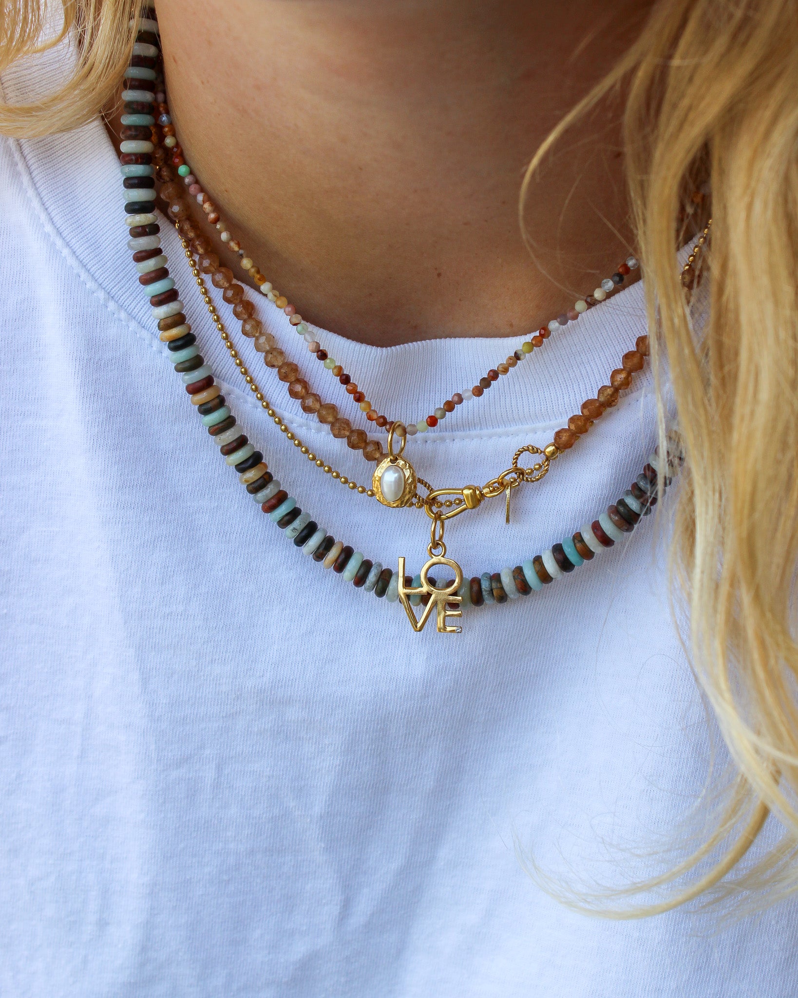 Gouden love bedel met bruine edelstenen kettingen