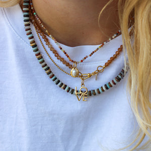 Gouden love bedel met bruine edelstenen kettingen