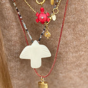 parel ketting vogel ketting met zwarte tand en rood koordje